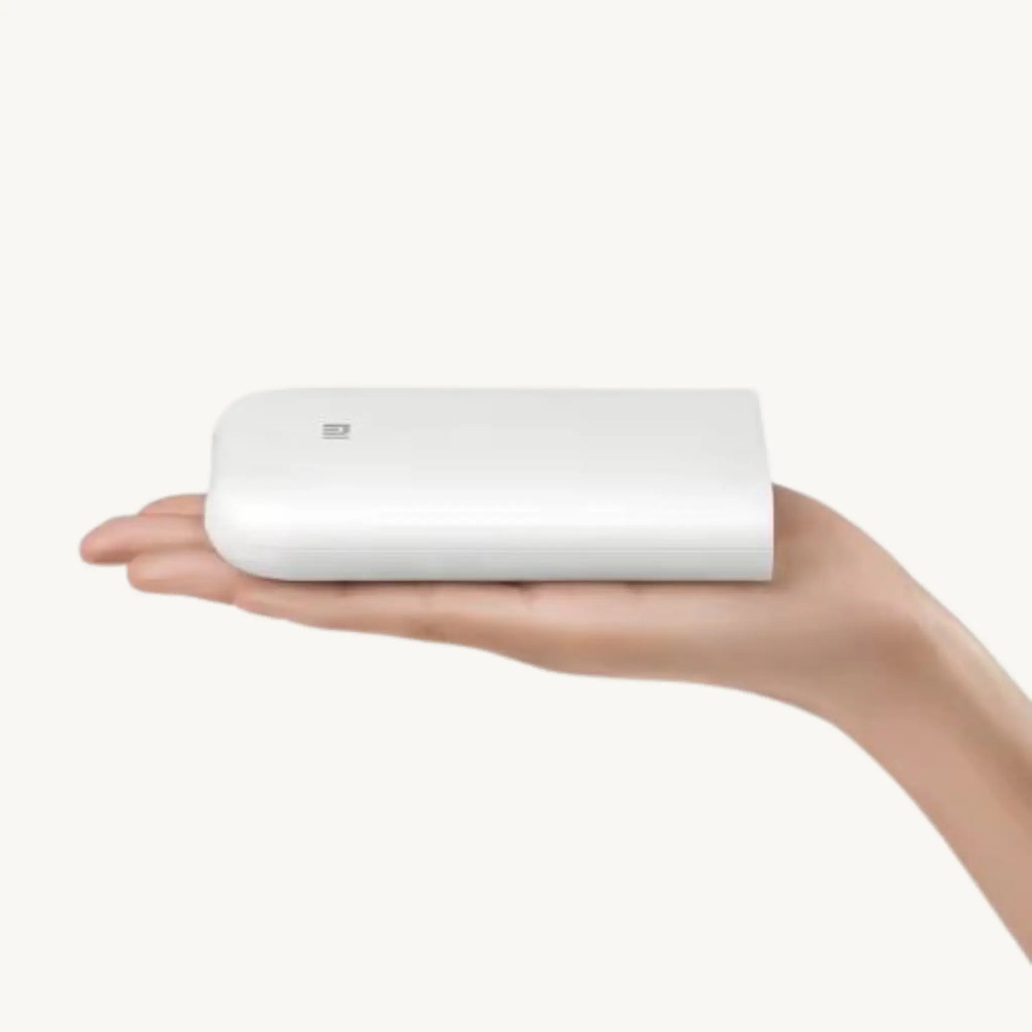 MEMOPRINT SNAP™ compact printer held in a hand, showcasing its portable design and user-friendliness.