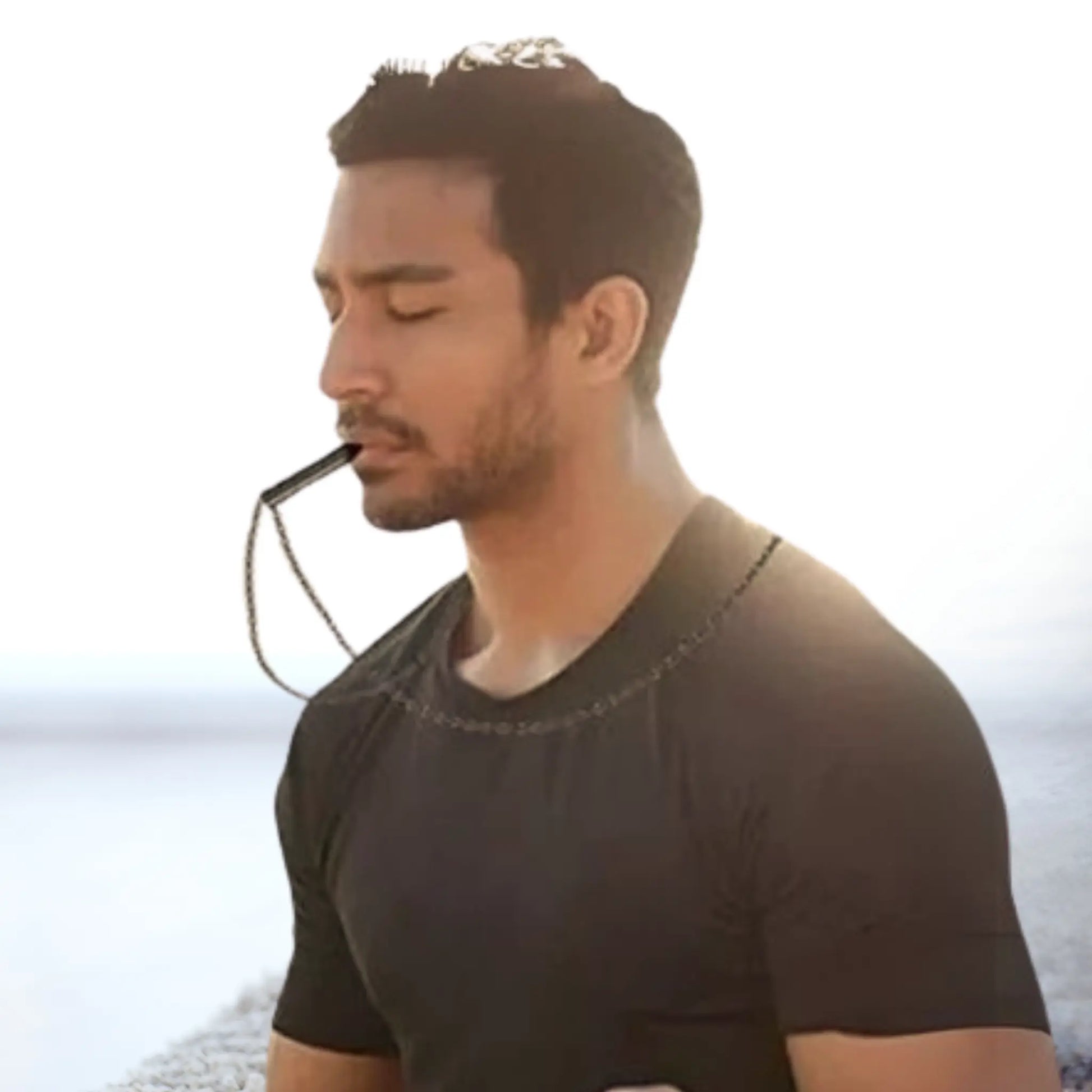 Man practicing mindful breathing with RESPIRA breathing necklace, promoting relaxation and stress relief.