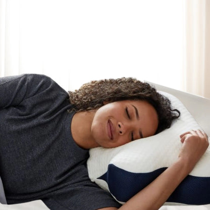 Vrouw ligt ontspannen op NEURA ergonomisch traagschuim kussen voor diepe rust en ondersteuning.